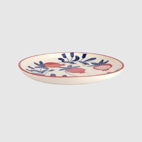 Ceramic plate with floral and fruit design on a white background